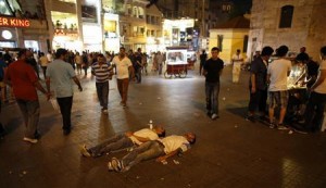 Two protesters lie on the ground of Taksim Square as they stage a silent protest in Istanbul