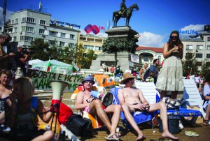 Protesters sunbathe during an initiative called "Beach revolution" as part of demonstration in front of parliament in Sofia